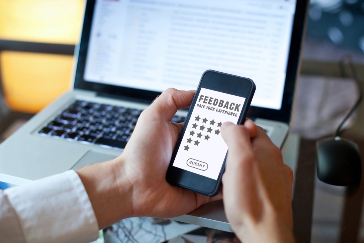 man holding phone reviewing something online