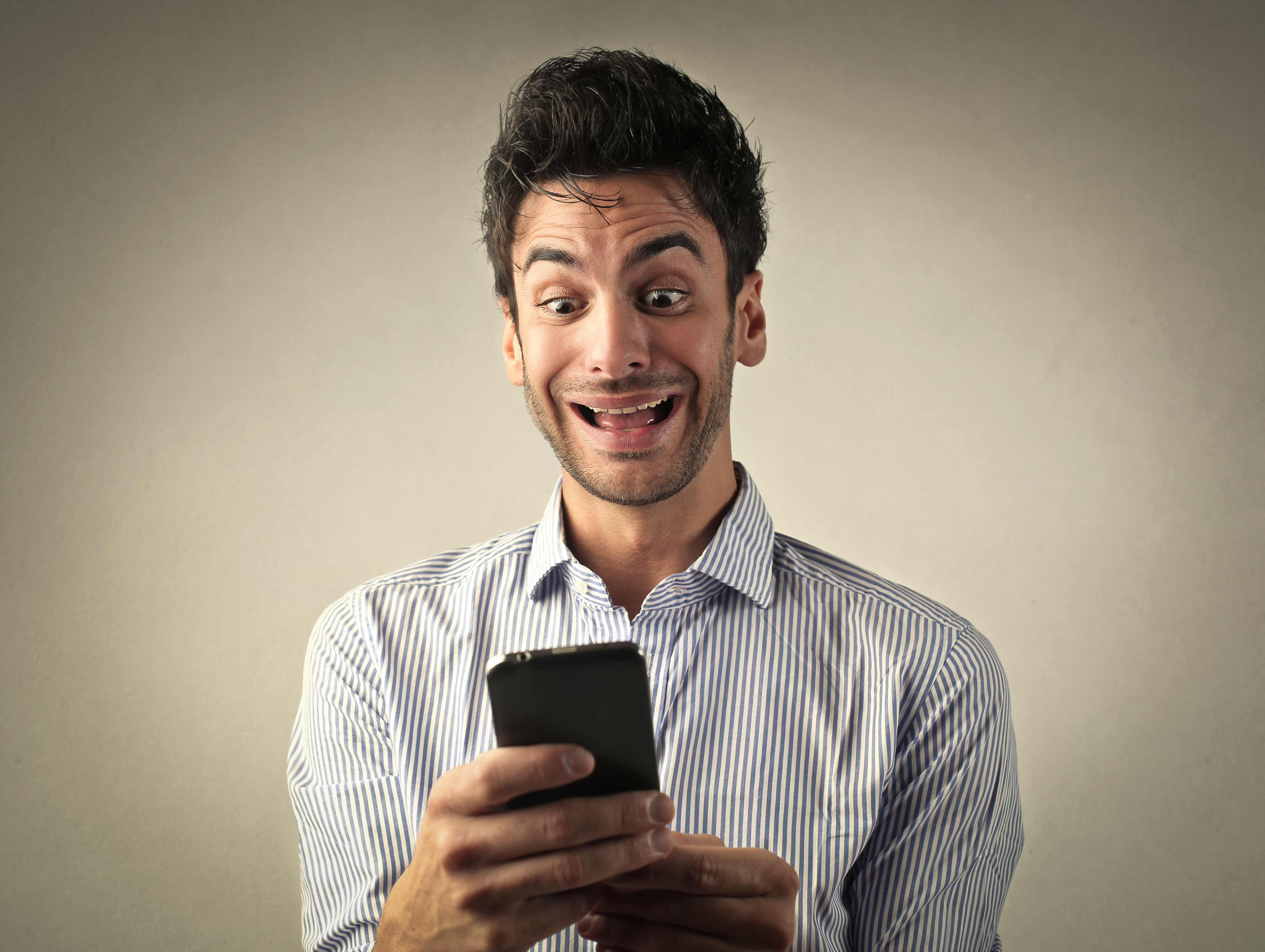 nerdy man looking excited while on his phone