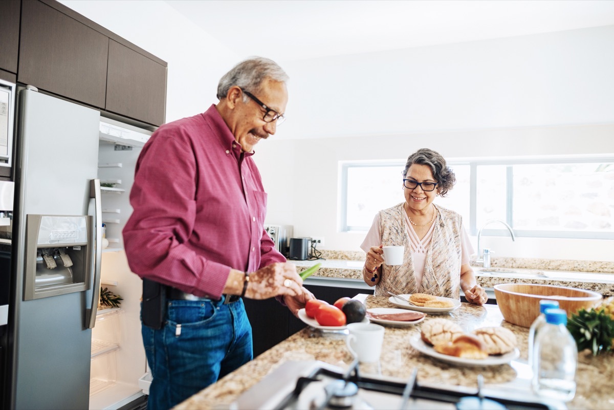 couple enjoying weekend with their grandchildren and family at home in summertime.