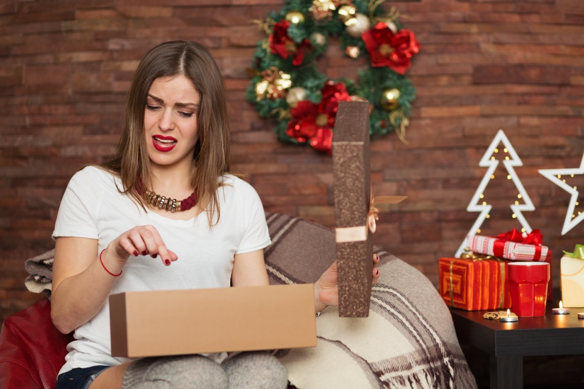 upset white woman opening christmas present