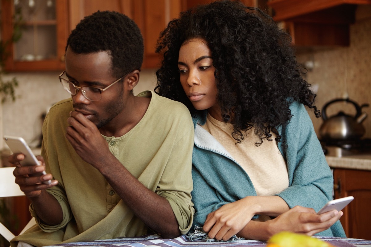 a woman spying over her partner's shoulder while he's on the phone, old-fashioned etiquette rules