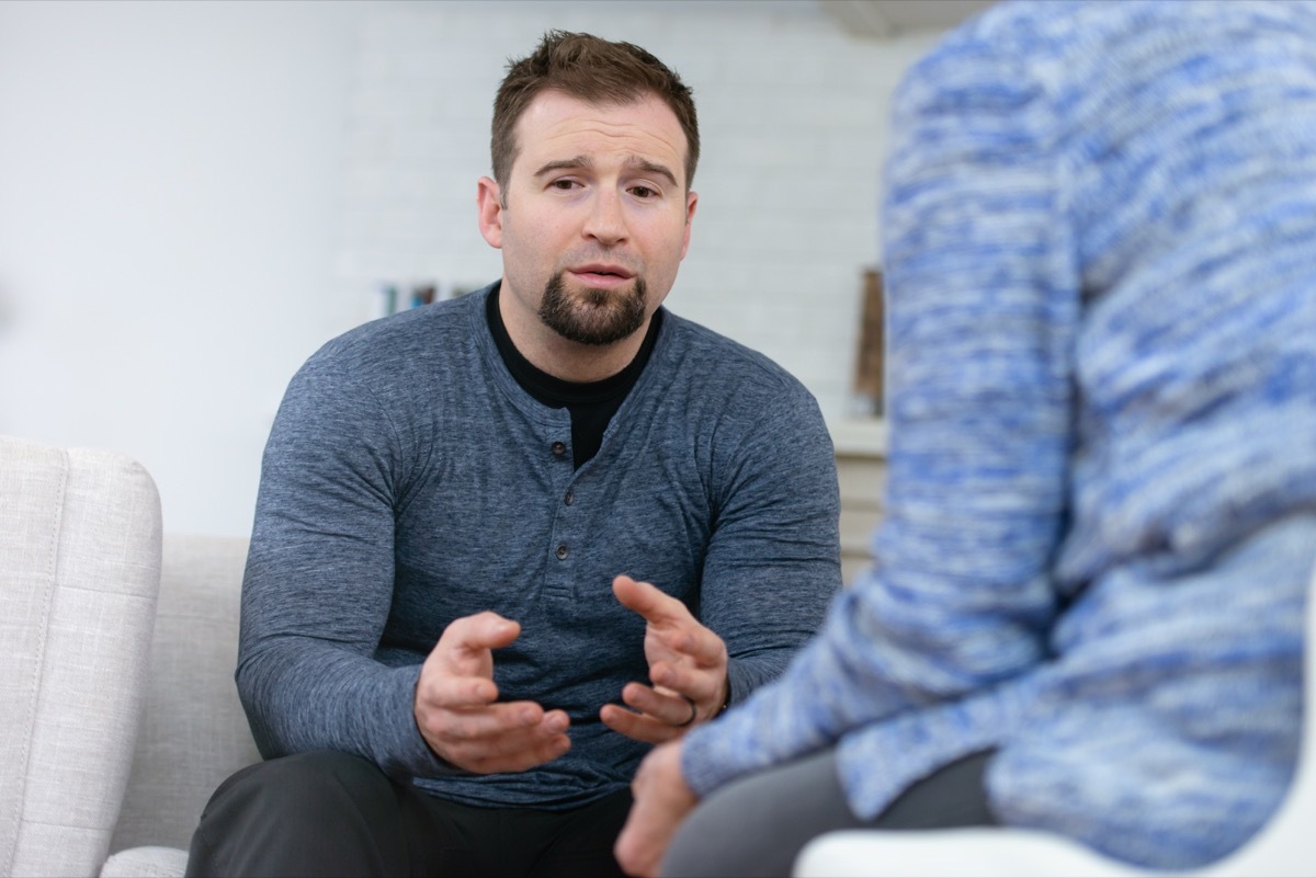 A young husband sits across from his therapist looking defeated. He is upset because he realizes that he has not been as attentive to his wife's needs as he should be.