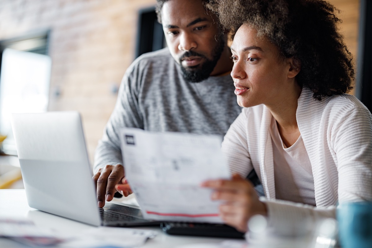 ouple paying their home bills over a computer. Focus is on woman.