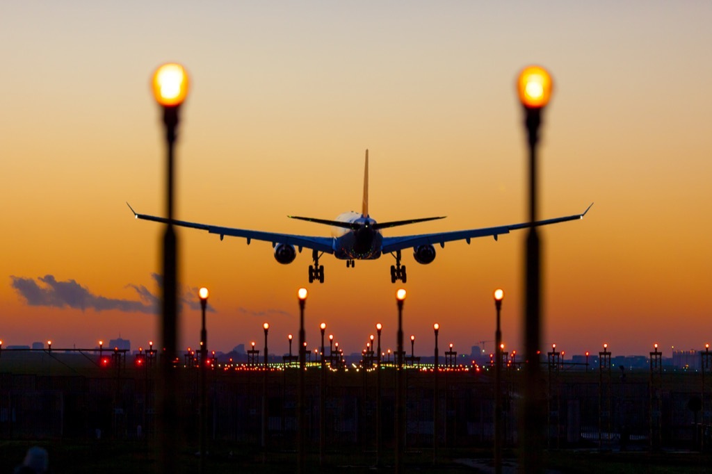 airplane landing at sunset