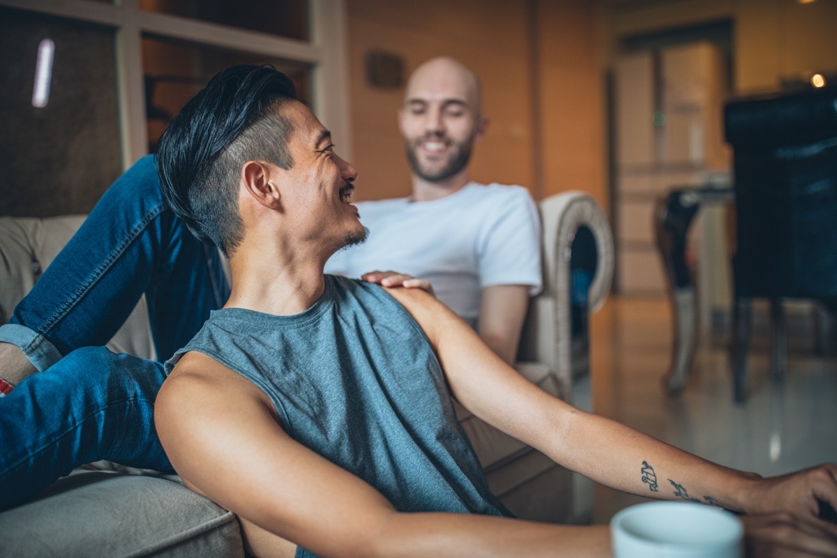 gay couple talking to each other about the future while sitting on the couch