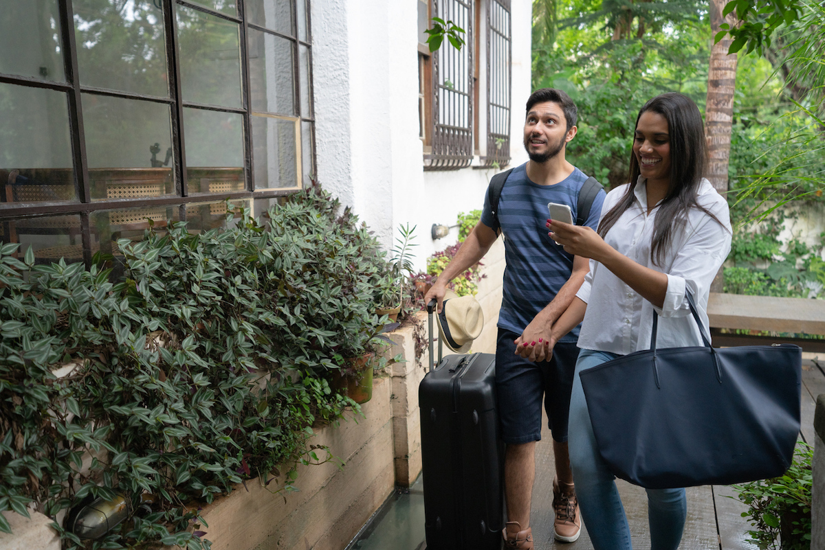 young couple arrive at rental house