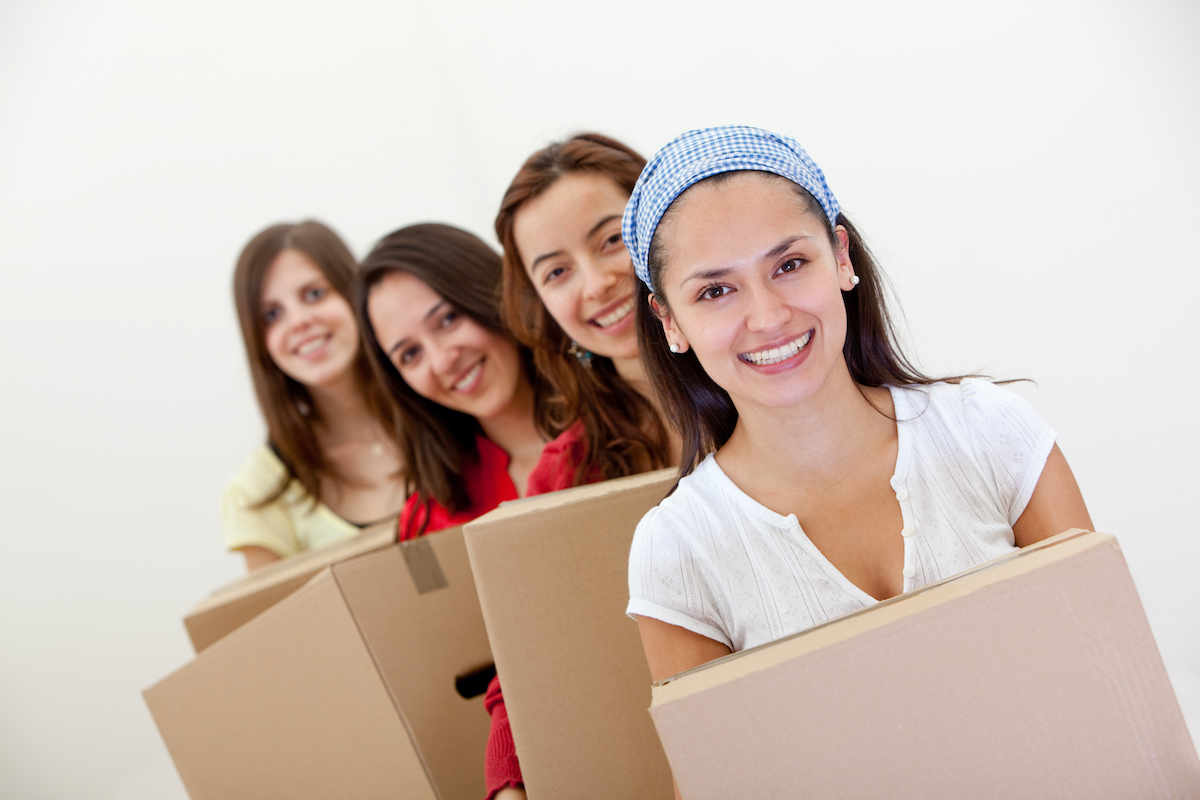 women carrying cardboard boxes