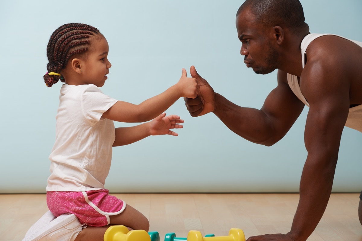 Dad thumb wrestling with daughter