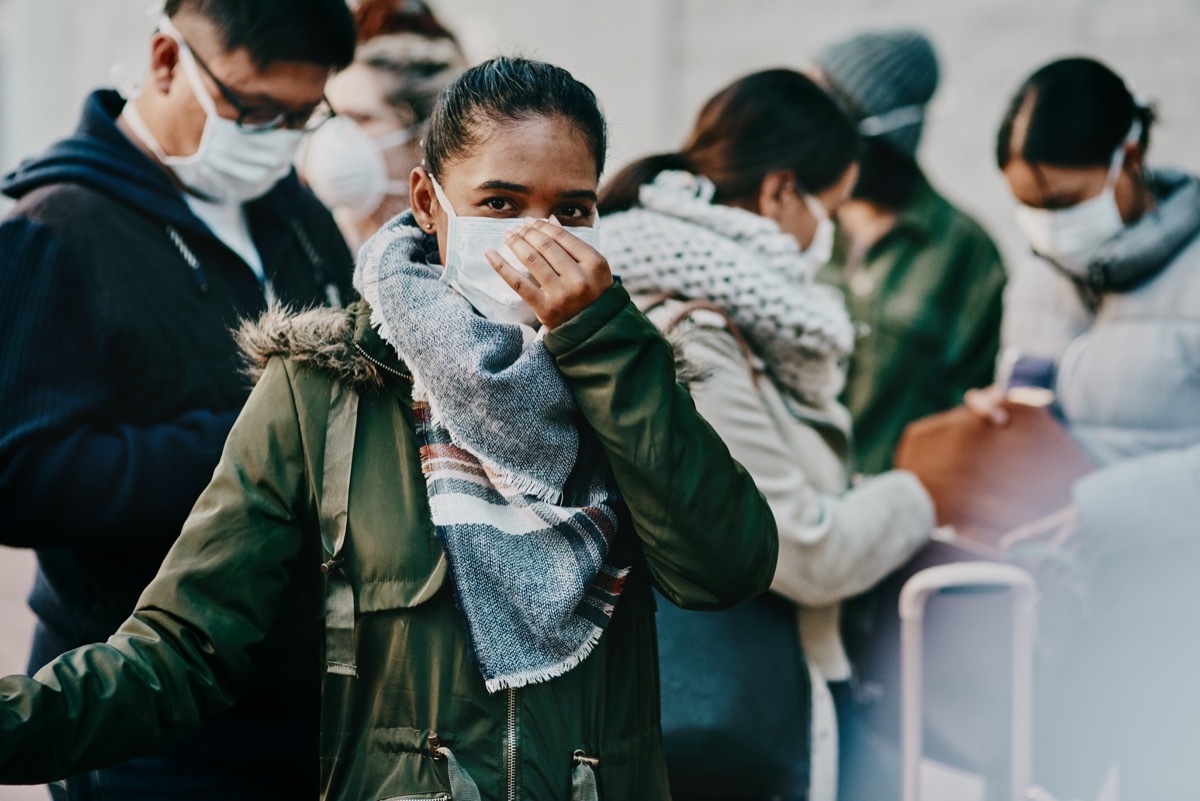 Shot of a group of young people wearing masks while travelling in a foreign city