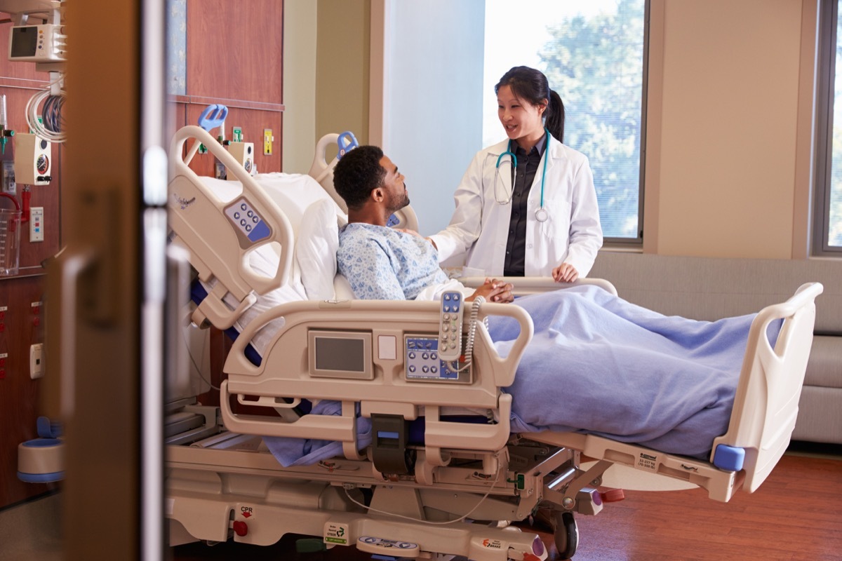 Man in hospital bed talking to doctor