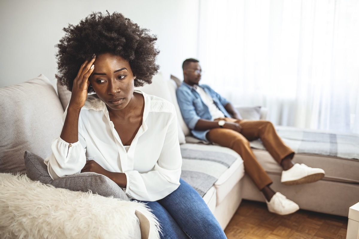 Unhappy Couple After an Argument in the Living Room at Home. Sad Pensive Young Girl Thinking of Relationships Problems Sitting on Sofa With Offended Boyfriend, Conflicts in Marriage,