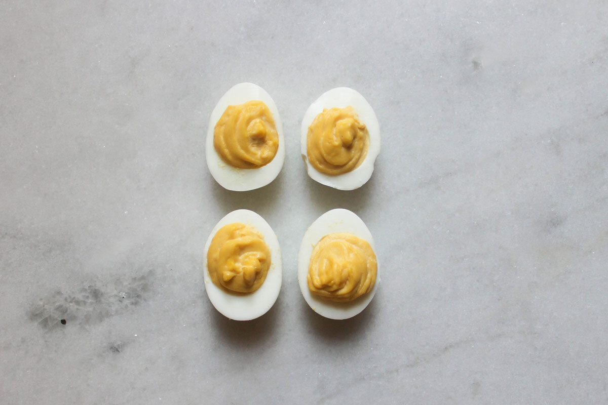 hummus deviled eggs on a marble counter