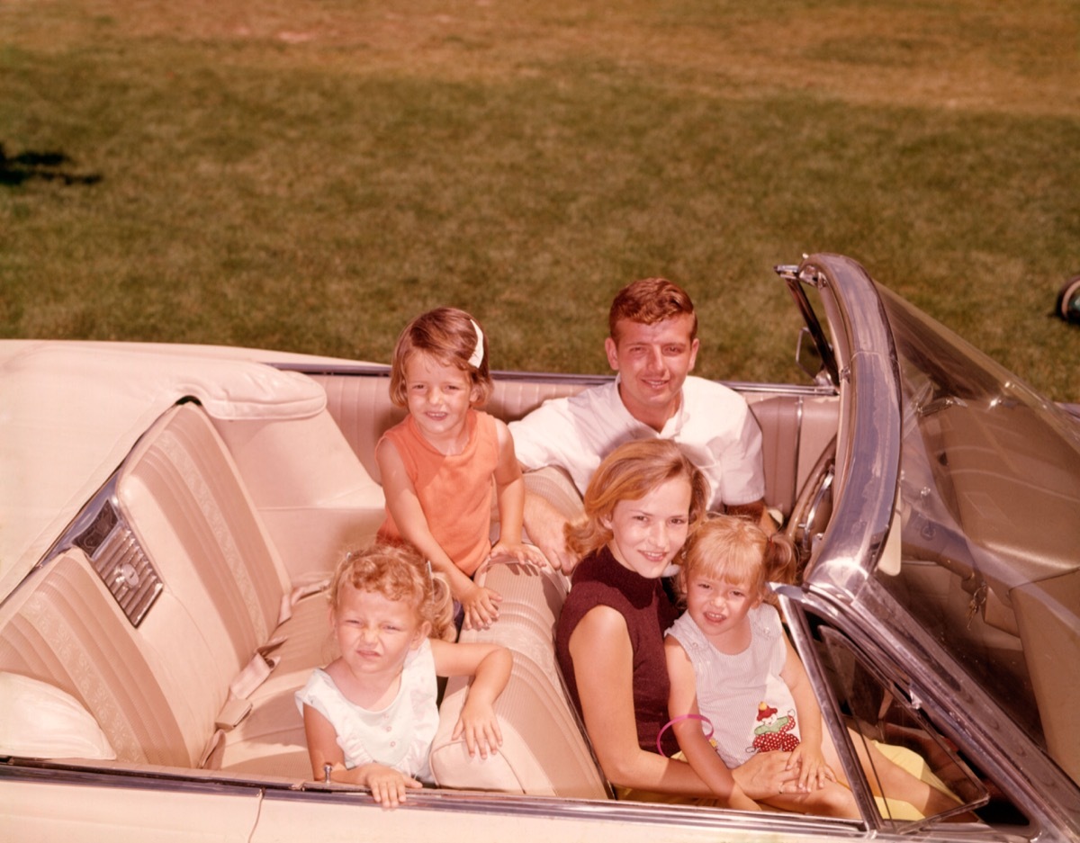 1960s white family with father, mother, daughter on lap in front seat, and two daughters in back seat, things that would horrify parents today