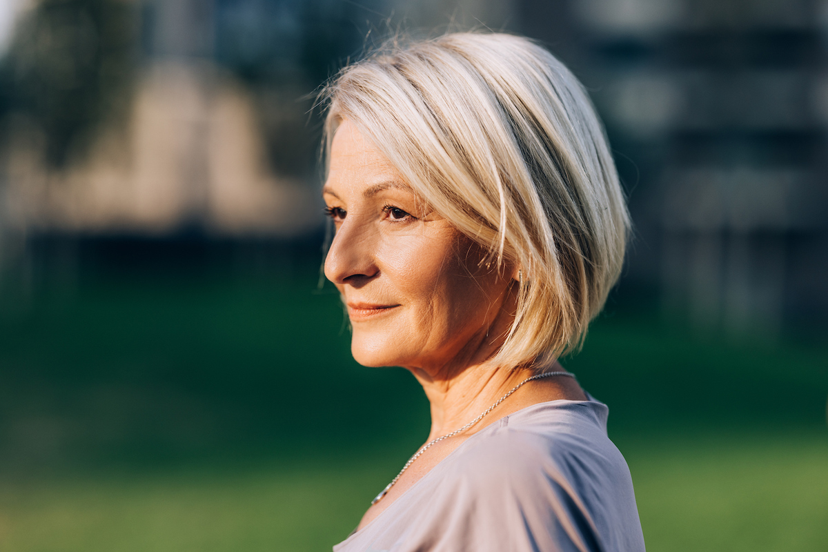 A side portrait of a senior Caucasian woman with short blonde hair.