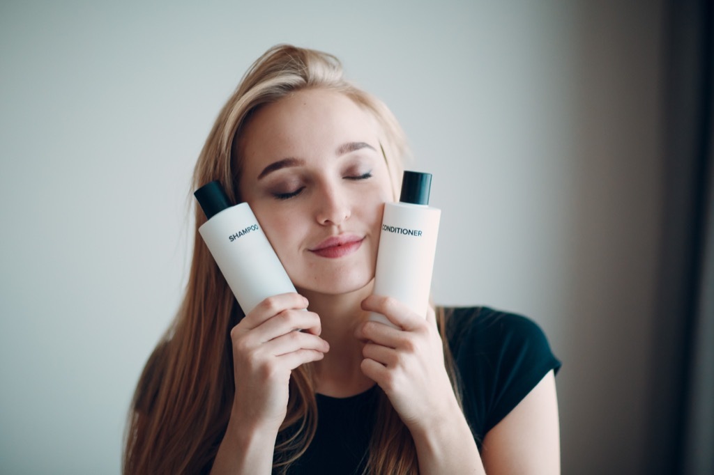 Woman holding shampoo before blowout