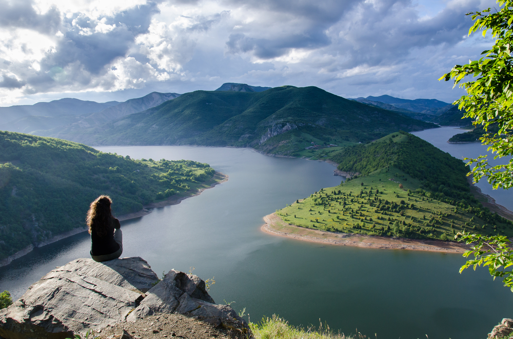 woman sitting alone on mountain