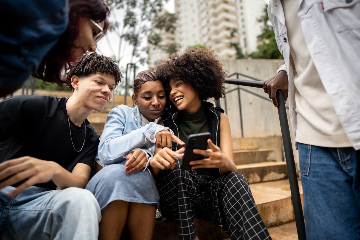 Friends using the mobile phone outdoors