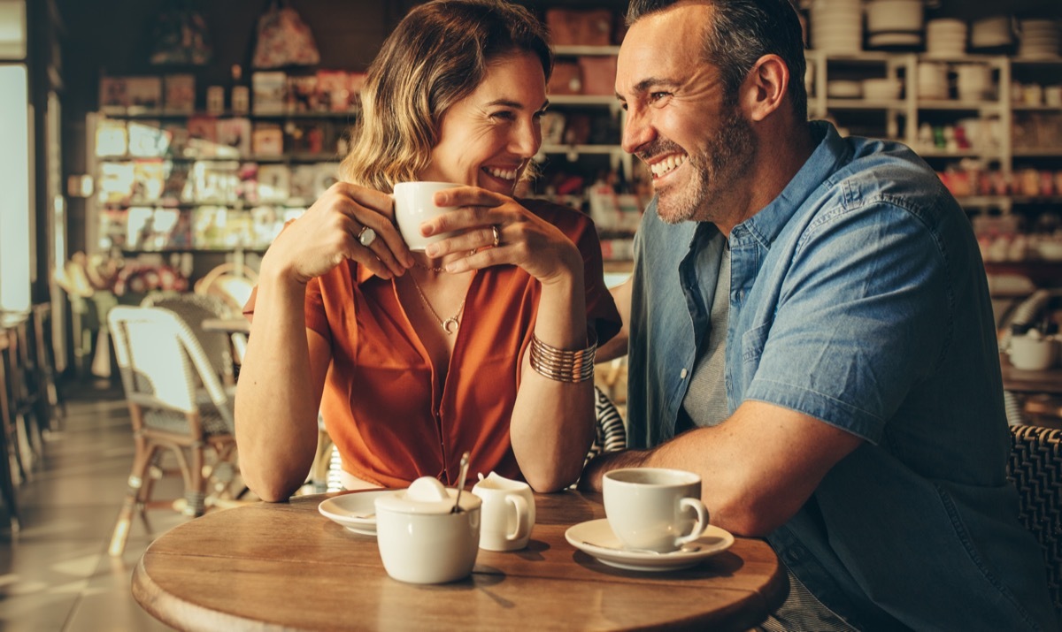 man and woman laughing over coffee