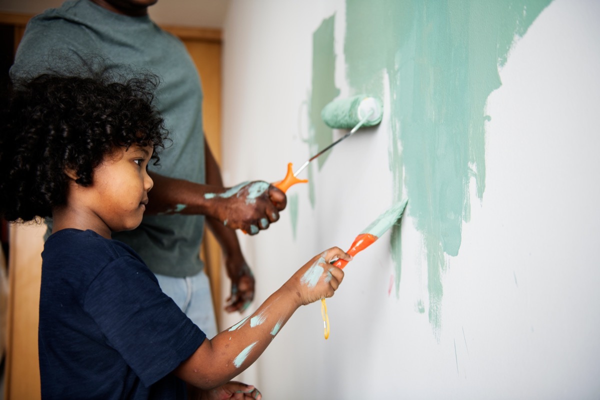 black father and son painting room green