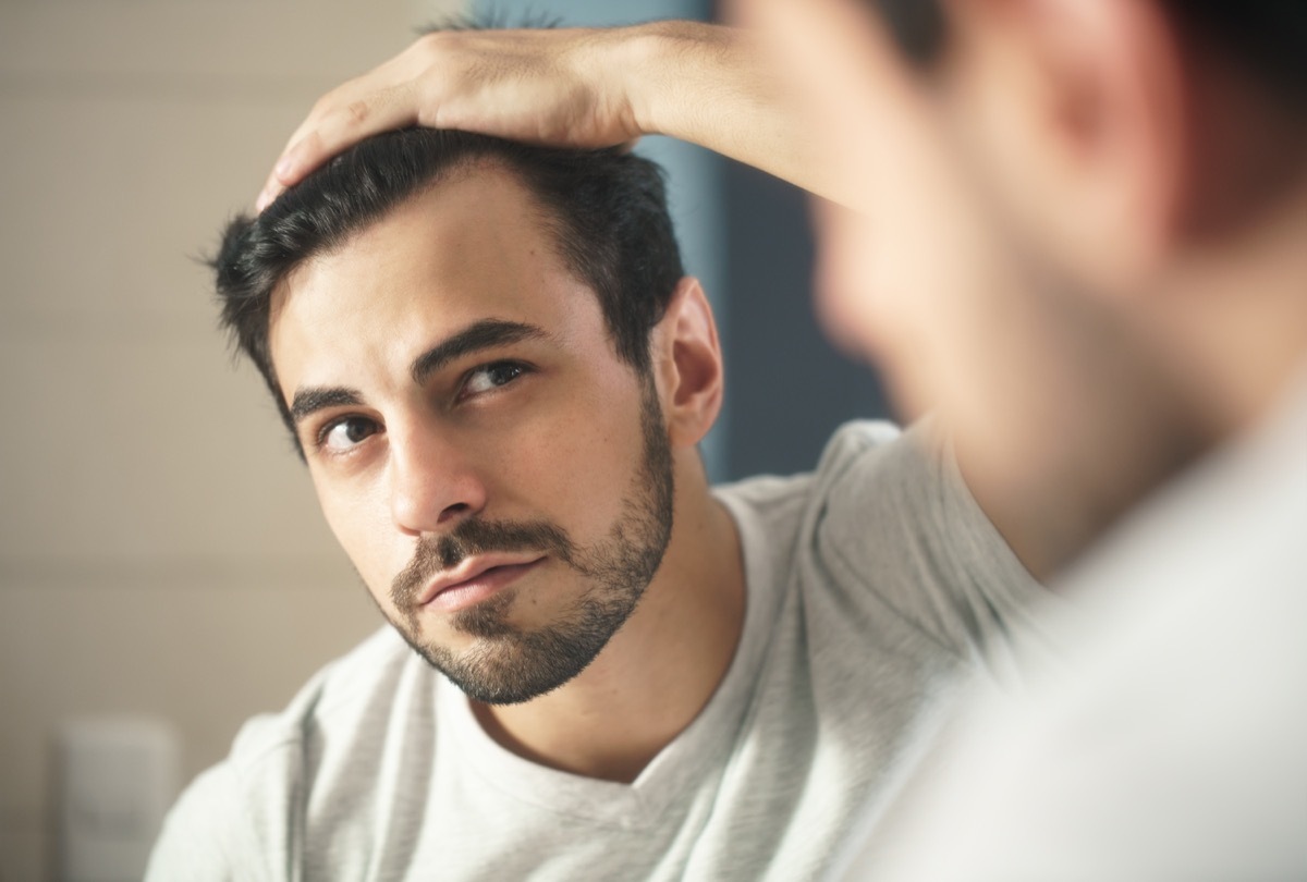 Man looking at his hair