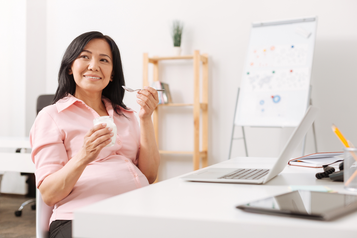 Pregnant woman eating yogurt