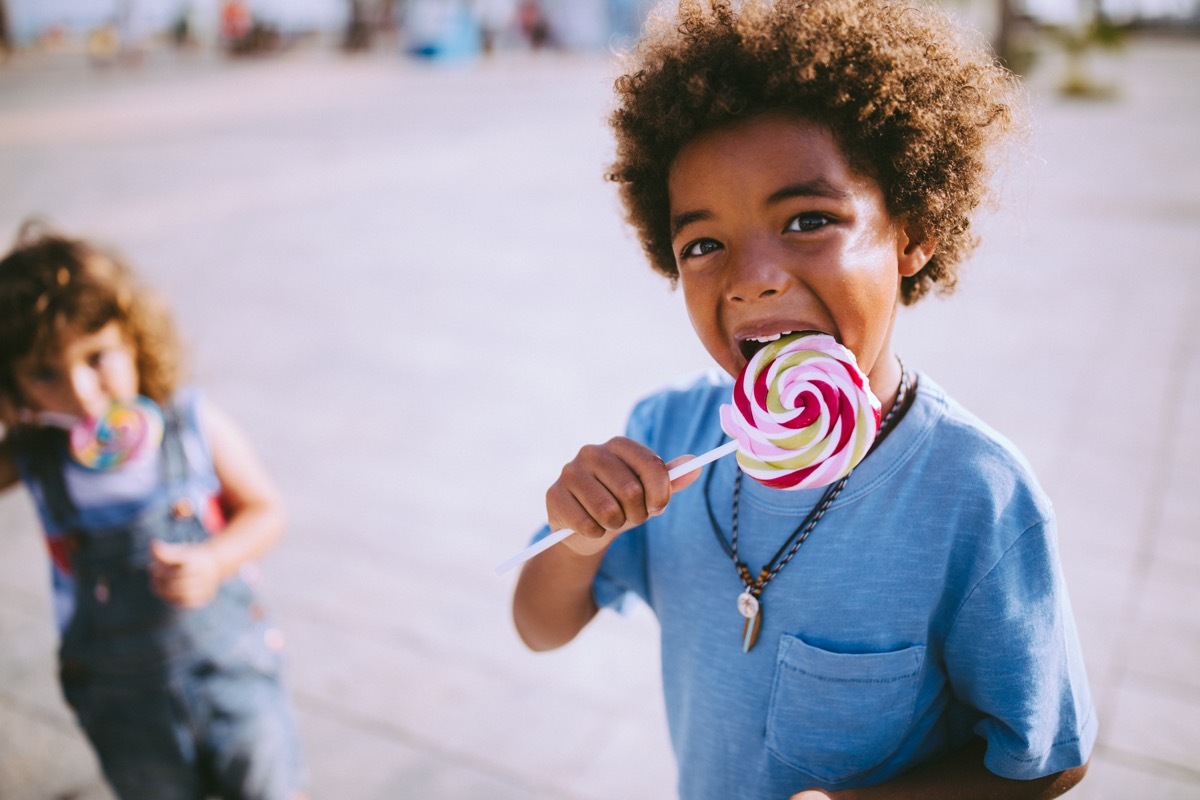 children with colorful lollipops outdoors on summer vacations