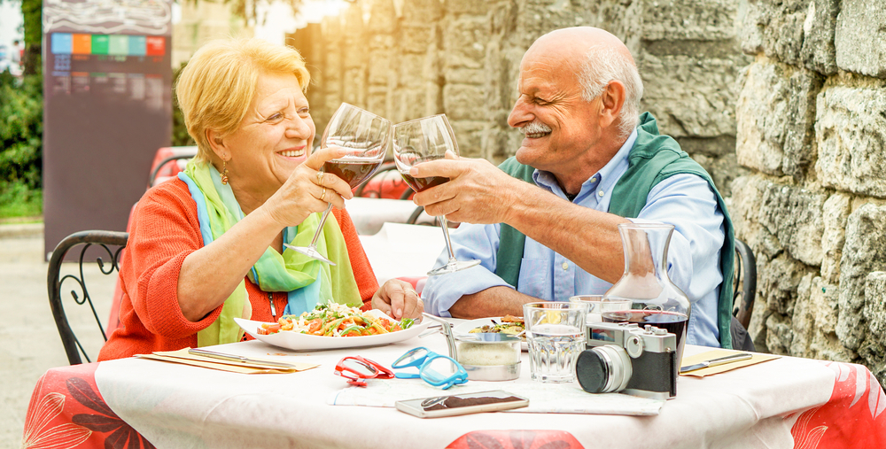 elderly couple drinks wine and eats in Italy