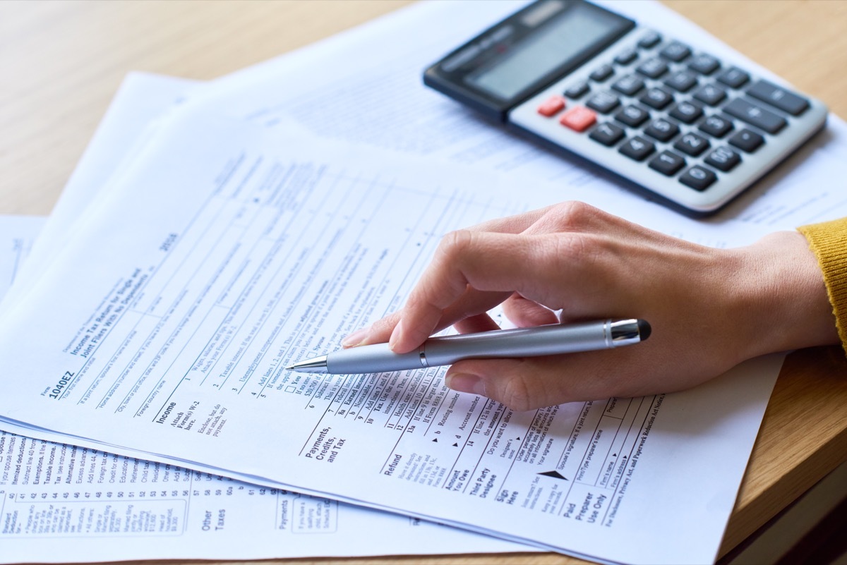 Close up of woman's hand holding pen and checking a tax form