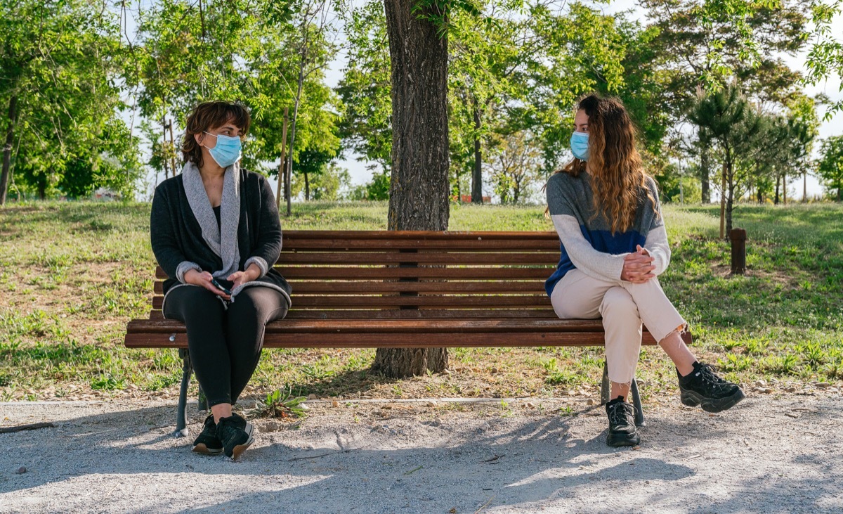 Mom and daughter social distancing on park bench