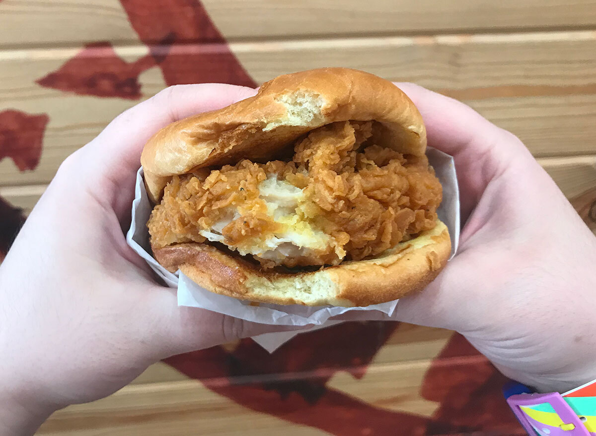 hands holding popeyes chicken sandwich