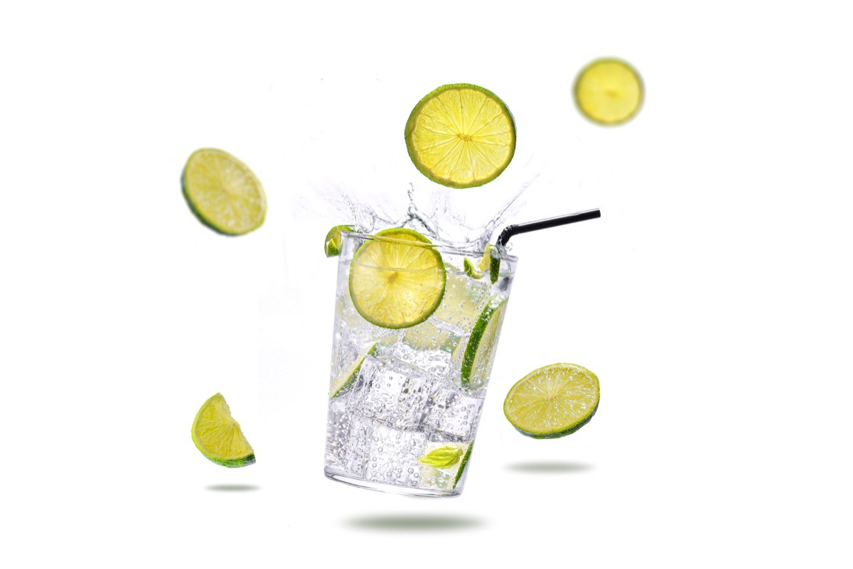 highball cocktail with lime, ice, glass, white background