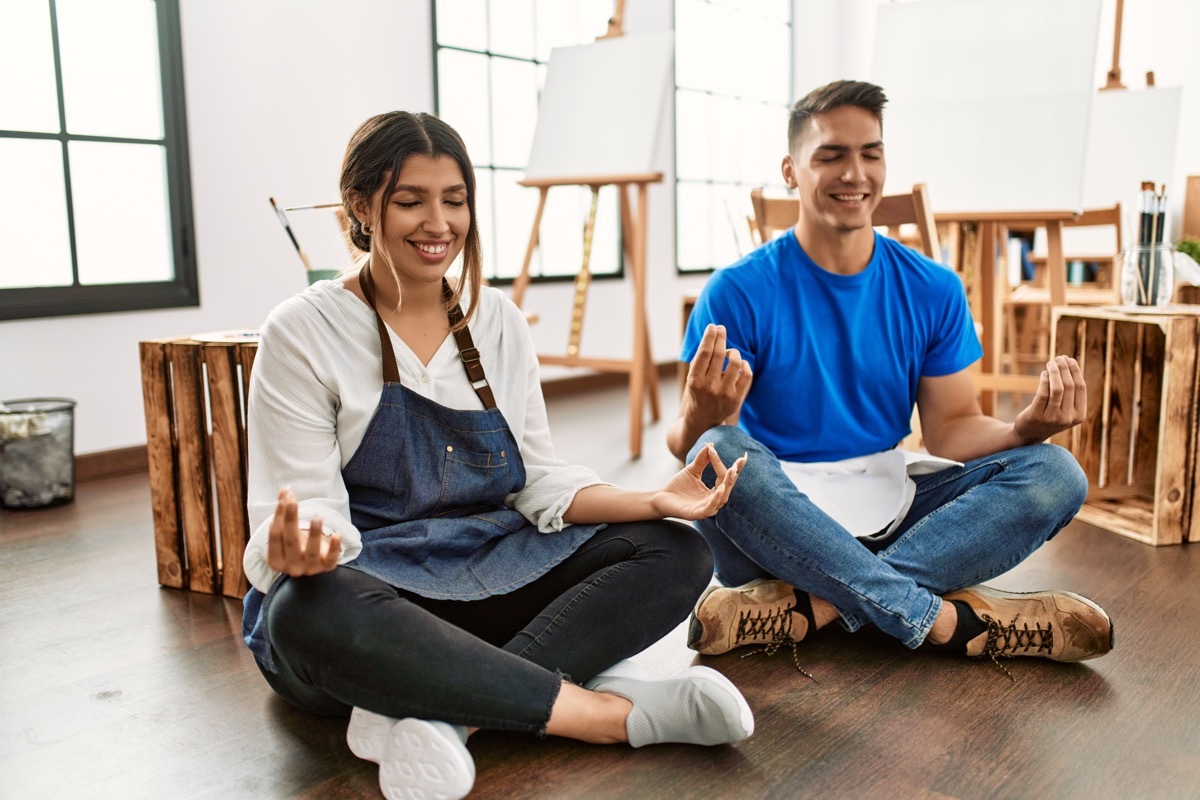 couple sitting on the floor doing yoga at an art class