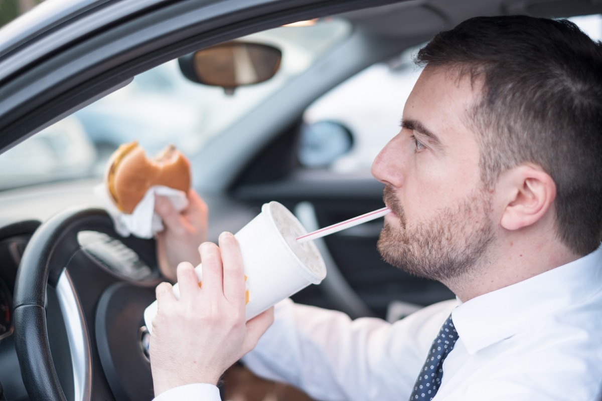 30 something white man eating fast food in car