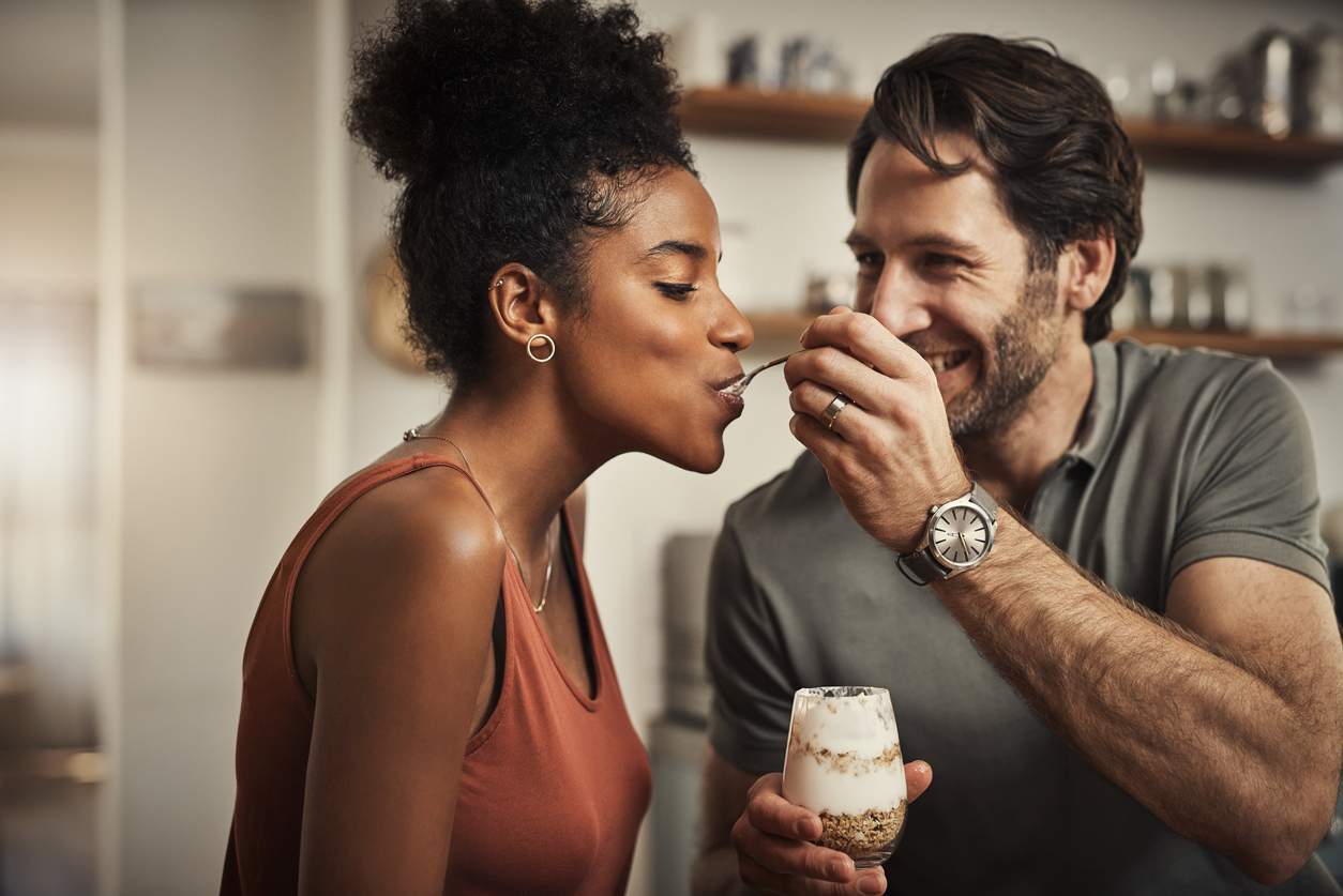 Cropped shot of an affectionate middle aged man feeding his wife dessert in their kitchen at home