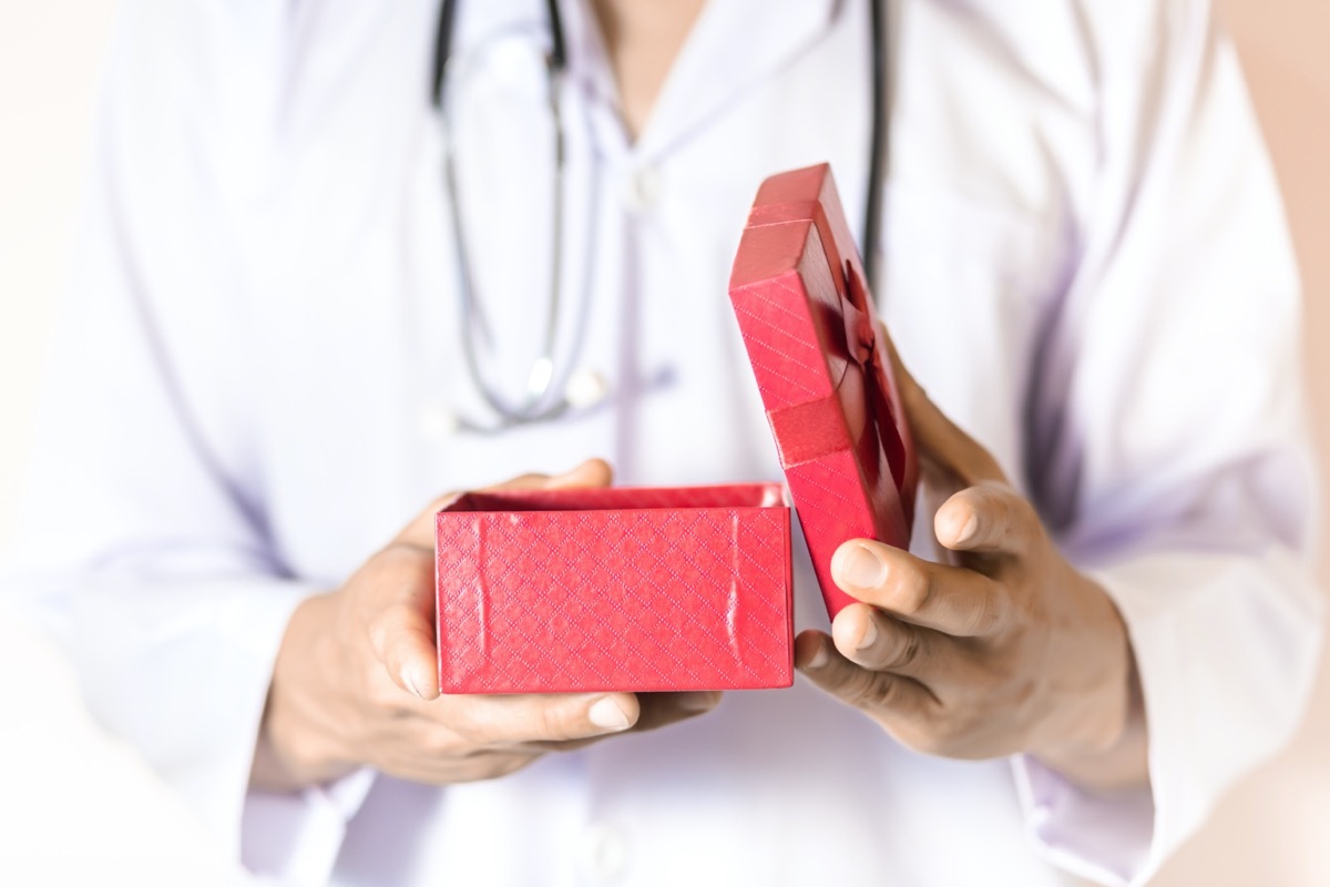 Doctor holding the red gift box in his hand