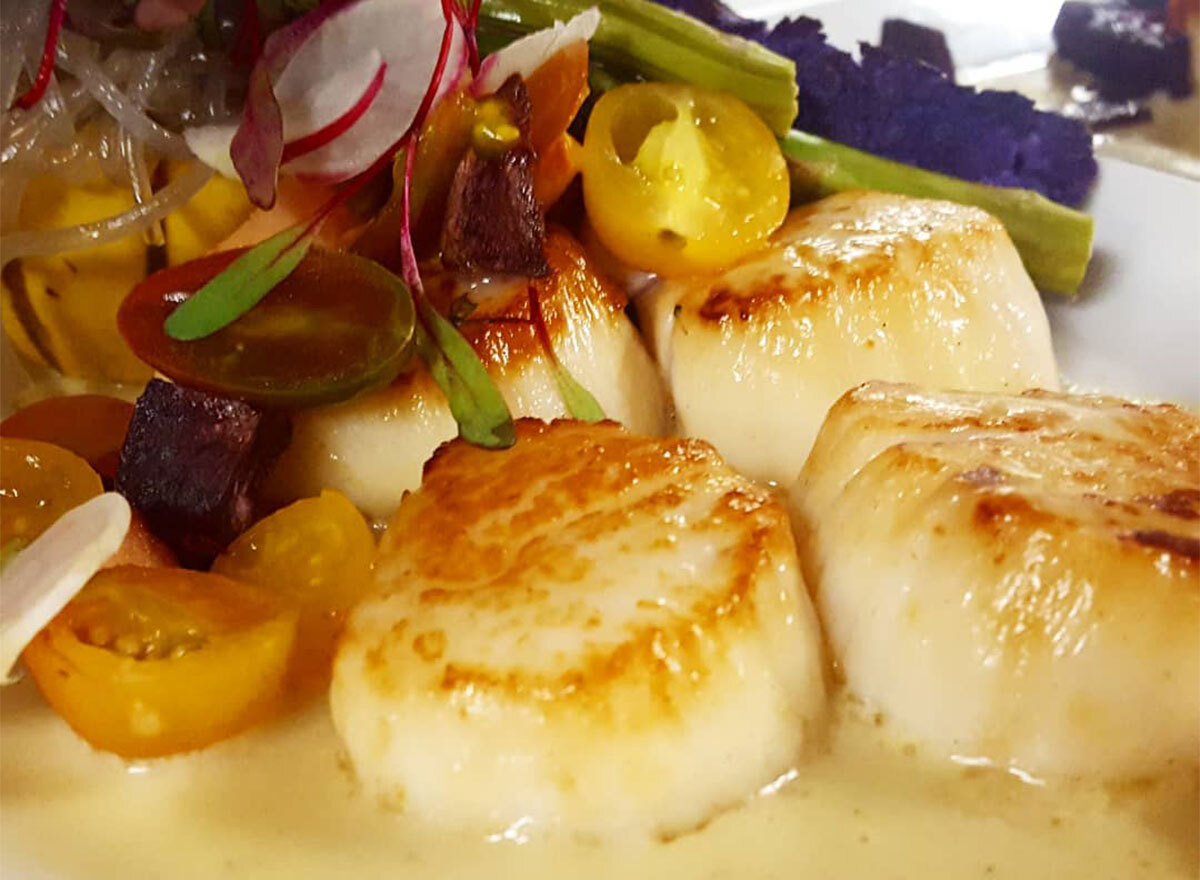 seared scallops with yellow sauce and vegetables