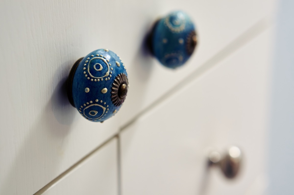 interesting blue cabinet knobs on a white cabinet