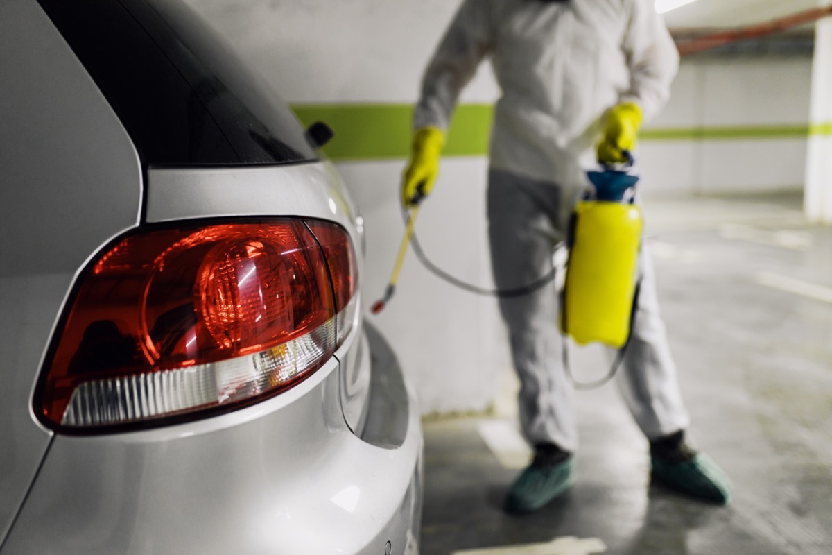 exterminator spraying car in garage