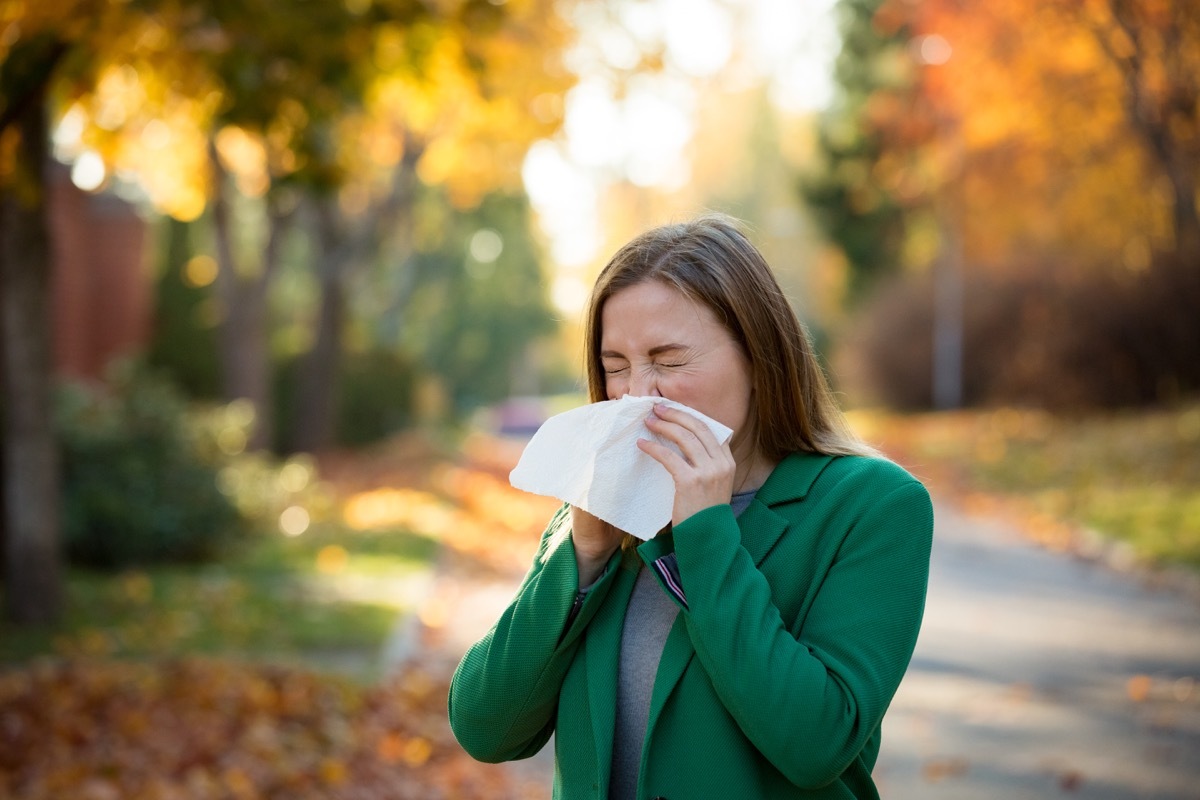 Woman sneezing into a tissue or handkerchief