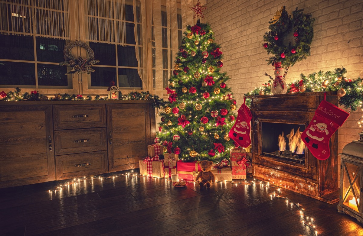 Christmas tree near fireplace in decorated living room