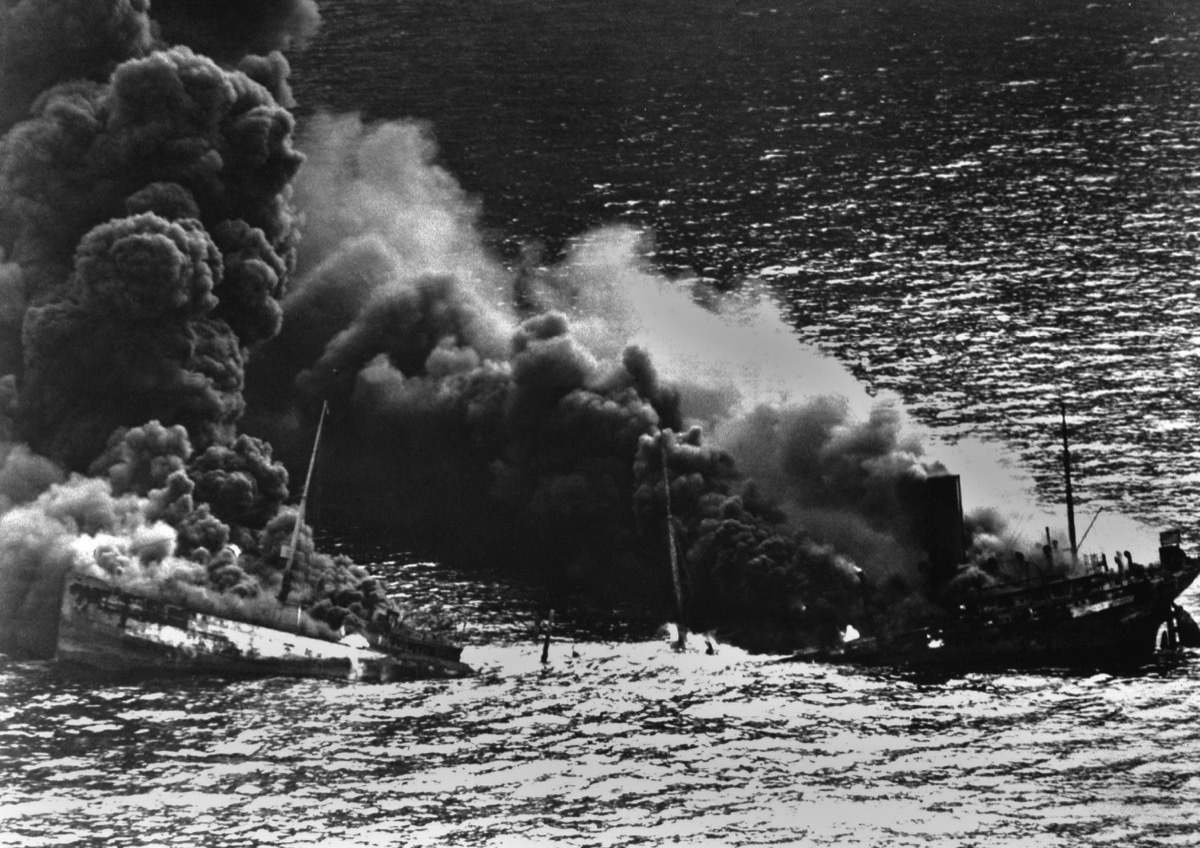 Allied tanker torpedoed in Atlantic Ocean by German submarine during World War 2. The ship crumbled amidships under heat of fire as she settled toward bottom of sea. 1942.