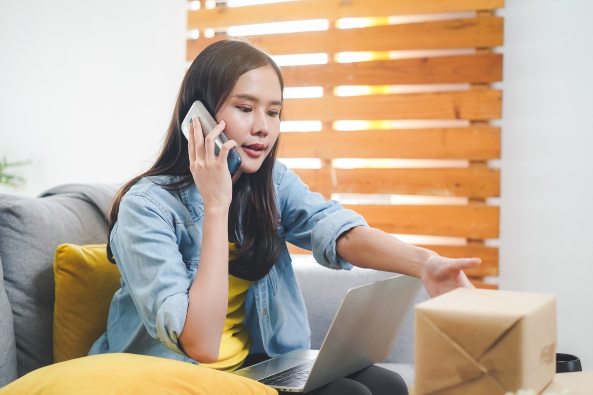 young woman returning package while on the phone