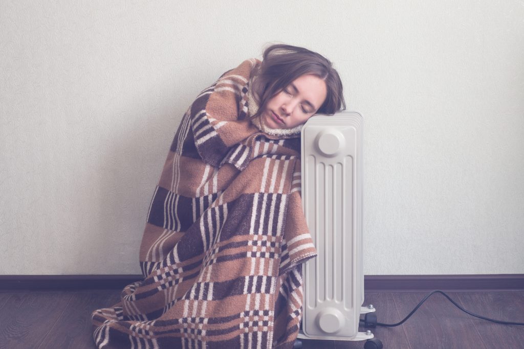 woman keeping warm by the radiator