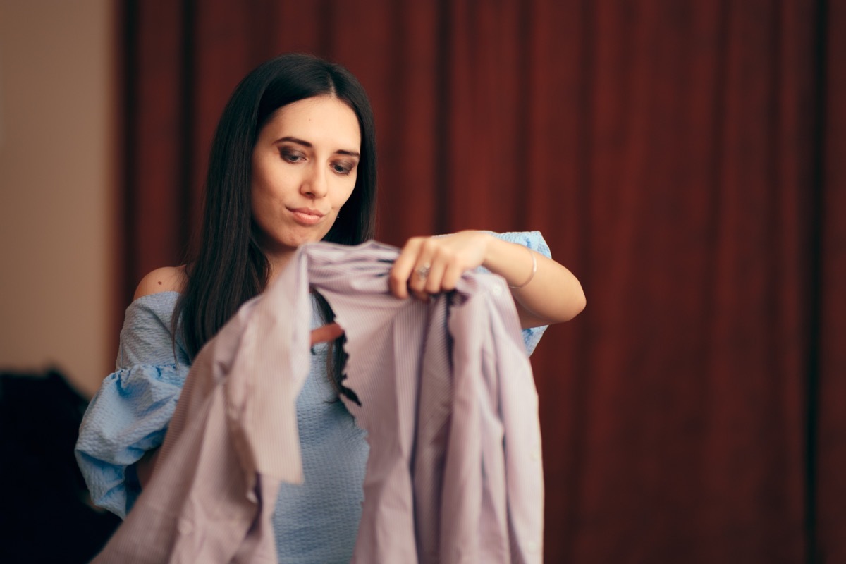 woman cutting up shirt as revenge