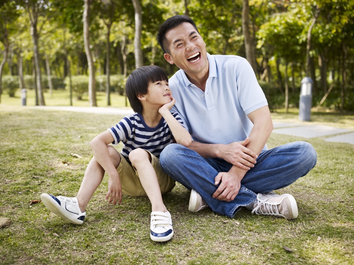 father and son laughing together in the park