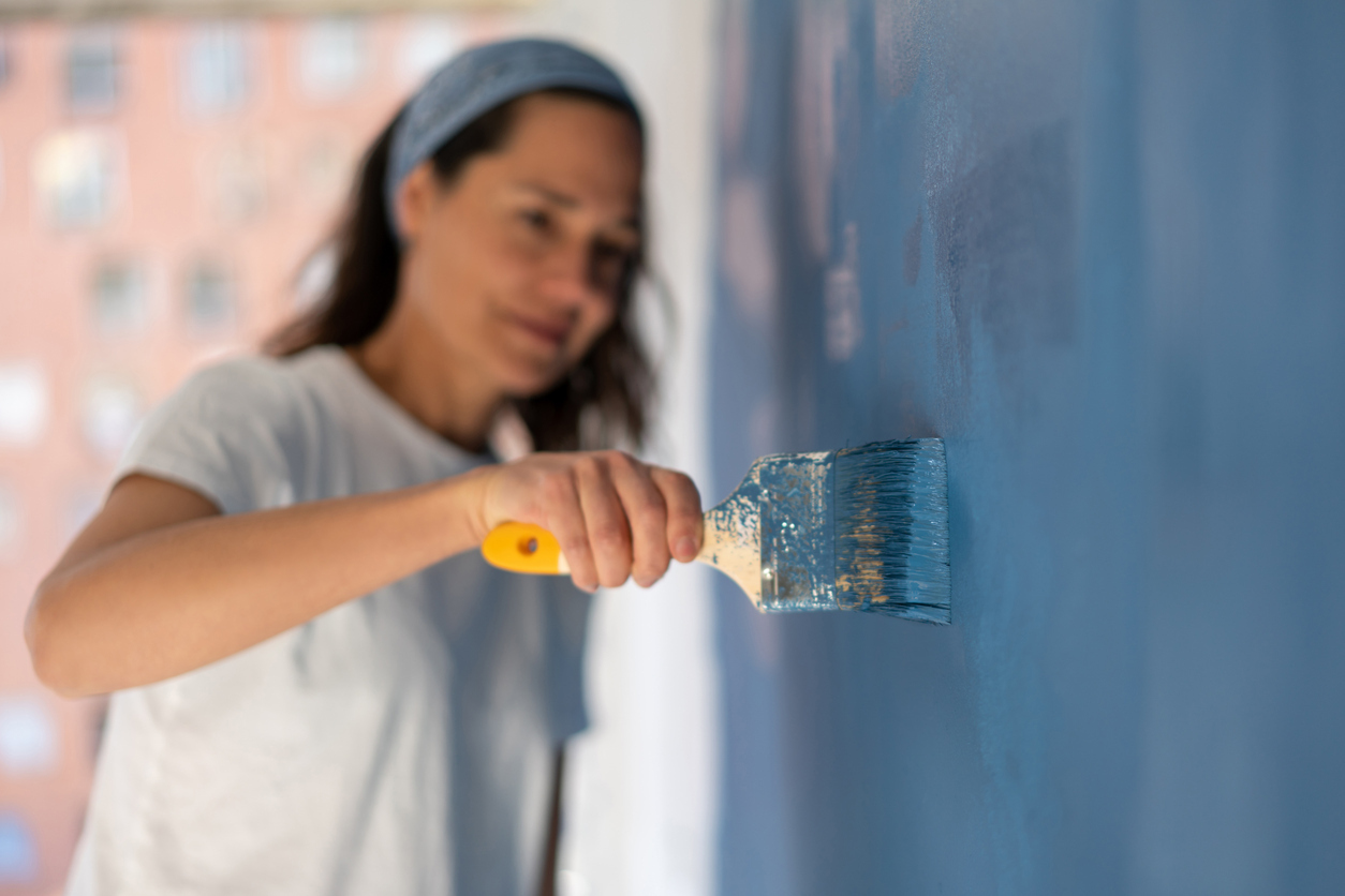 Close-up on a woman painting her house