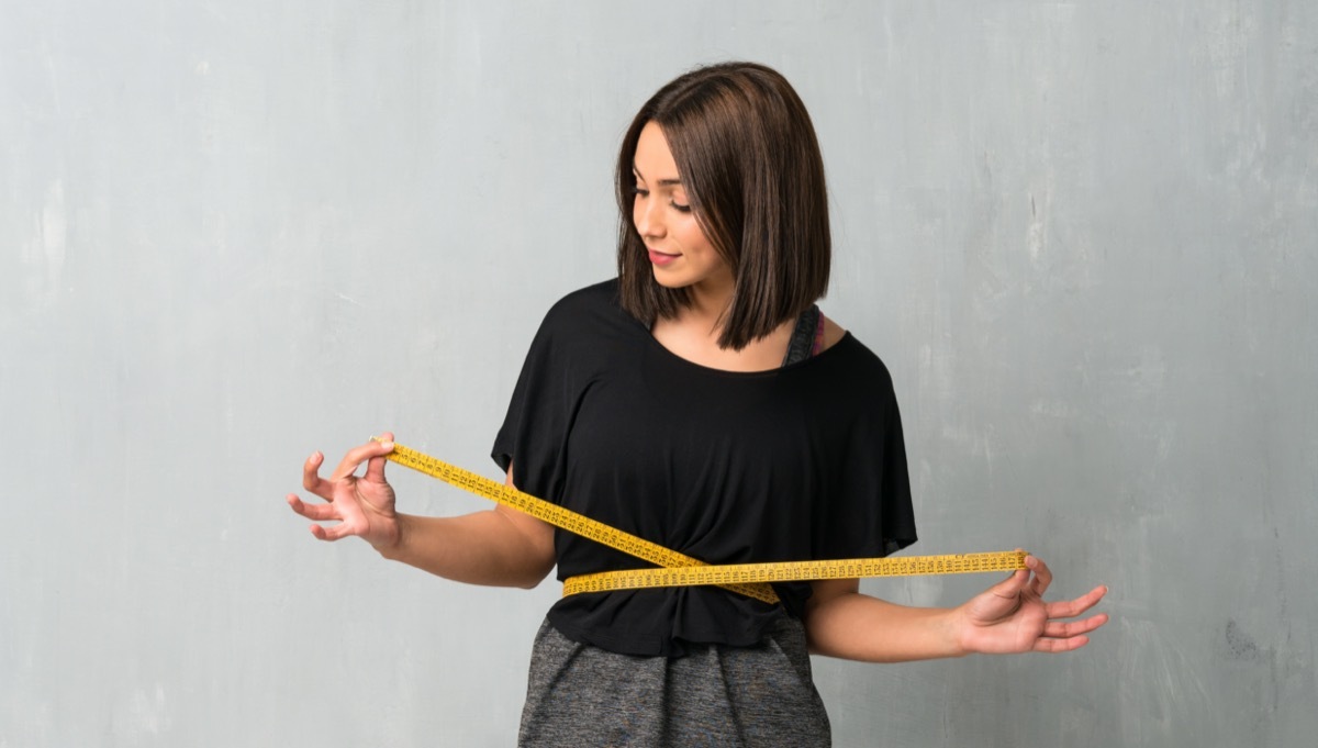 Young sport woman with tape measure