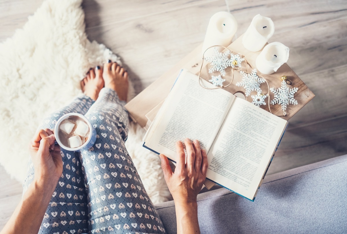 sheepskin rug with woman sitting on top and reading