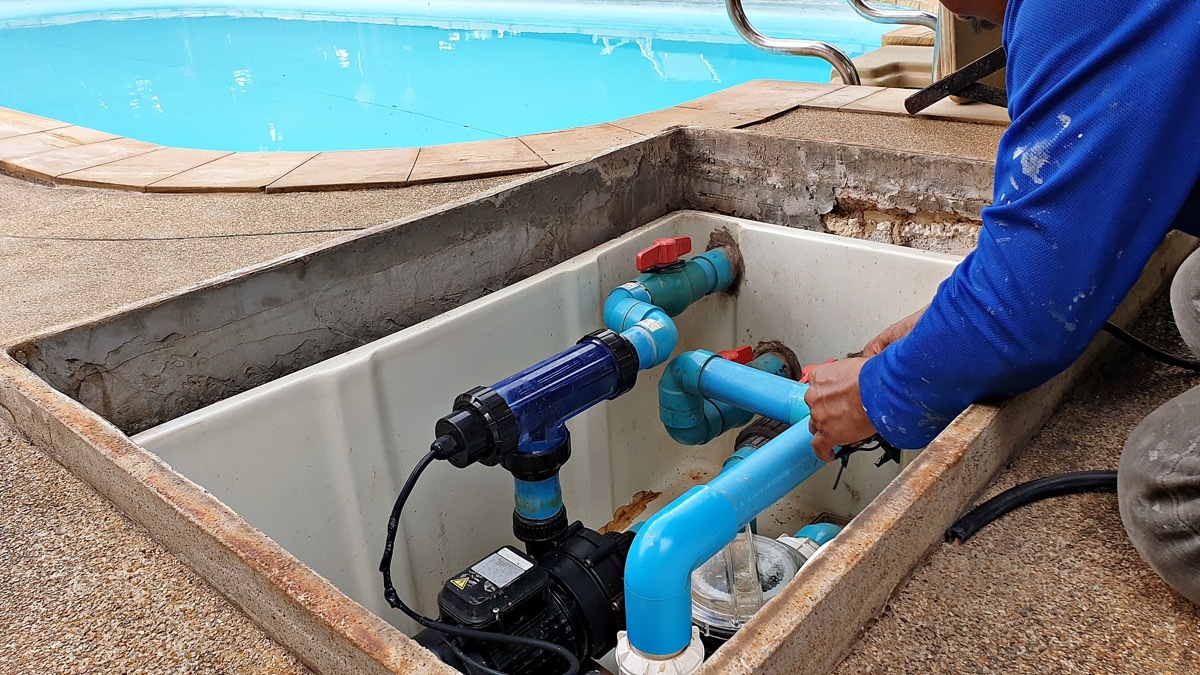 man repairing pool heater