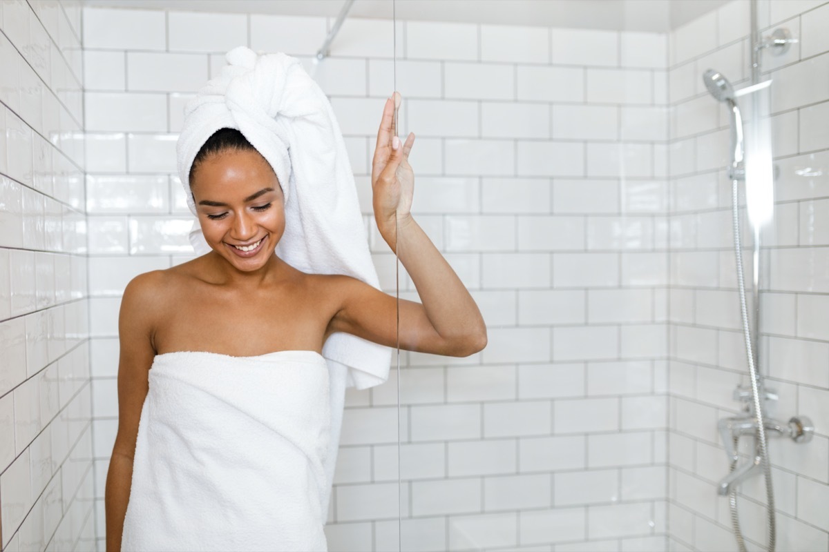 woman in white towels wrapped around head and body after shower.